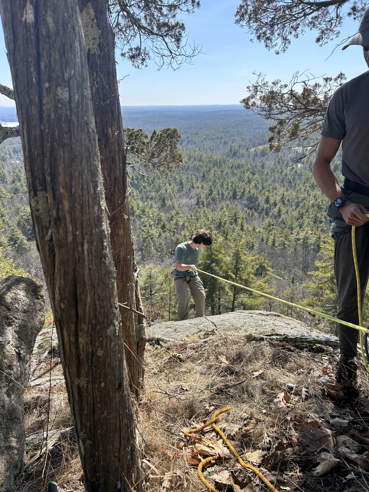 A Northeastern climbing club member being lowered down a 200 foot cliff