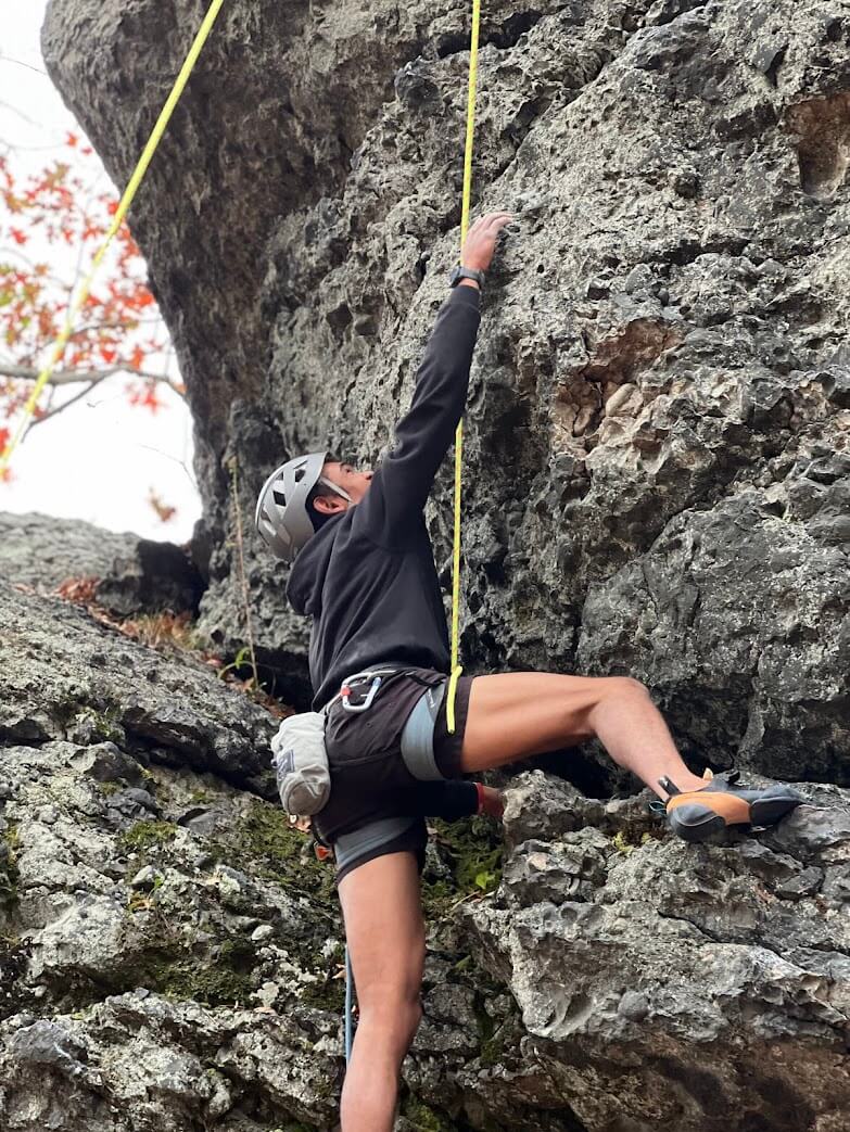 A Northeastern Recreational Climbing club member as they climb a outdoor route at a NRC climbing event