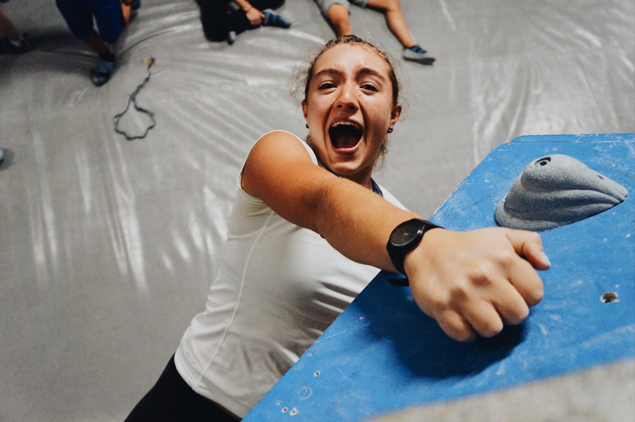A climber with an excited expression as they reach the top of a climb
